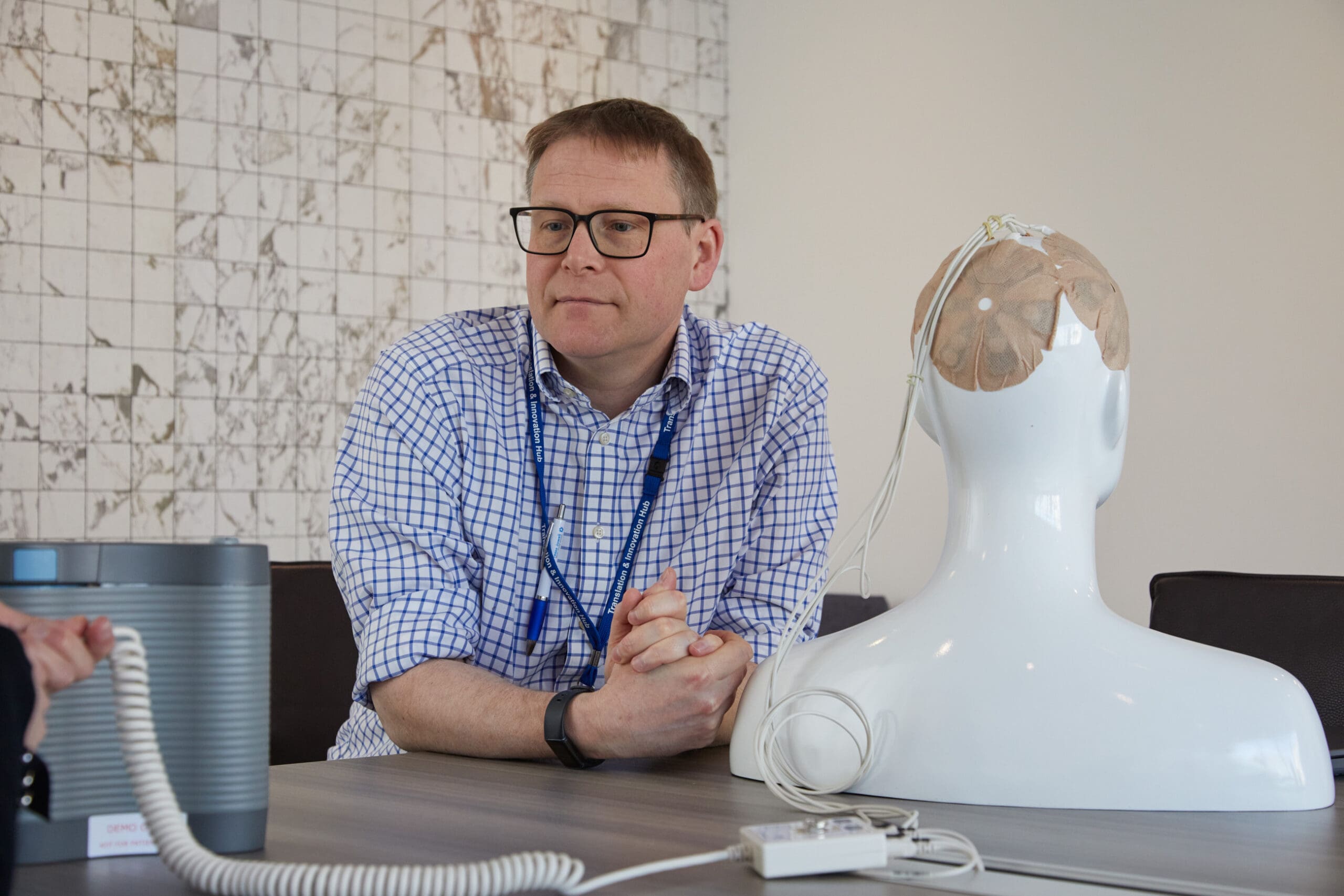 Dr Williams demonstrating an Optune device